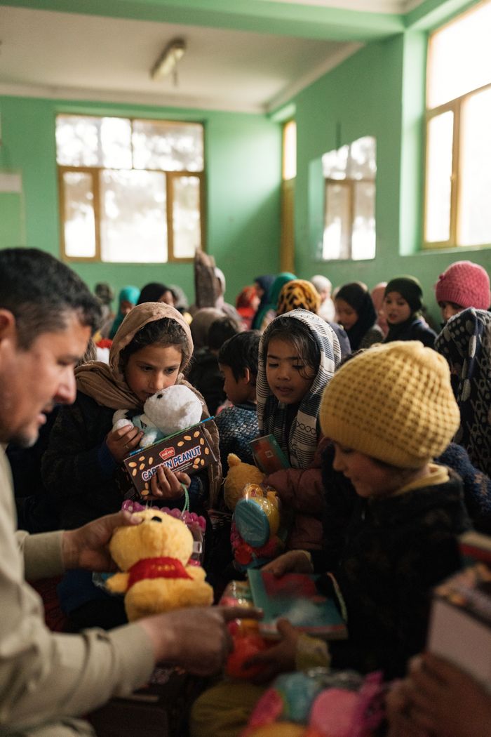 gallery-2 Children in Afghanistan enjoy receiving toys in a bright indoor setting, fostering joy and cultural connection.